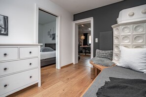Un dormitorio moderno con cama, cómoda, mesita de noche y un mueble decorativo de pared grande.