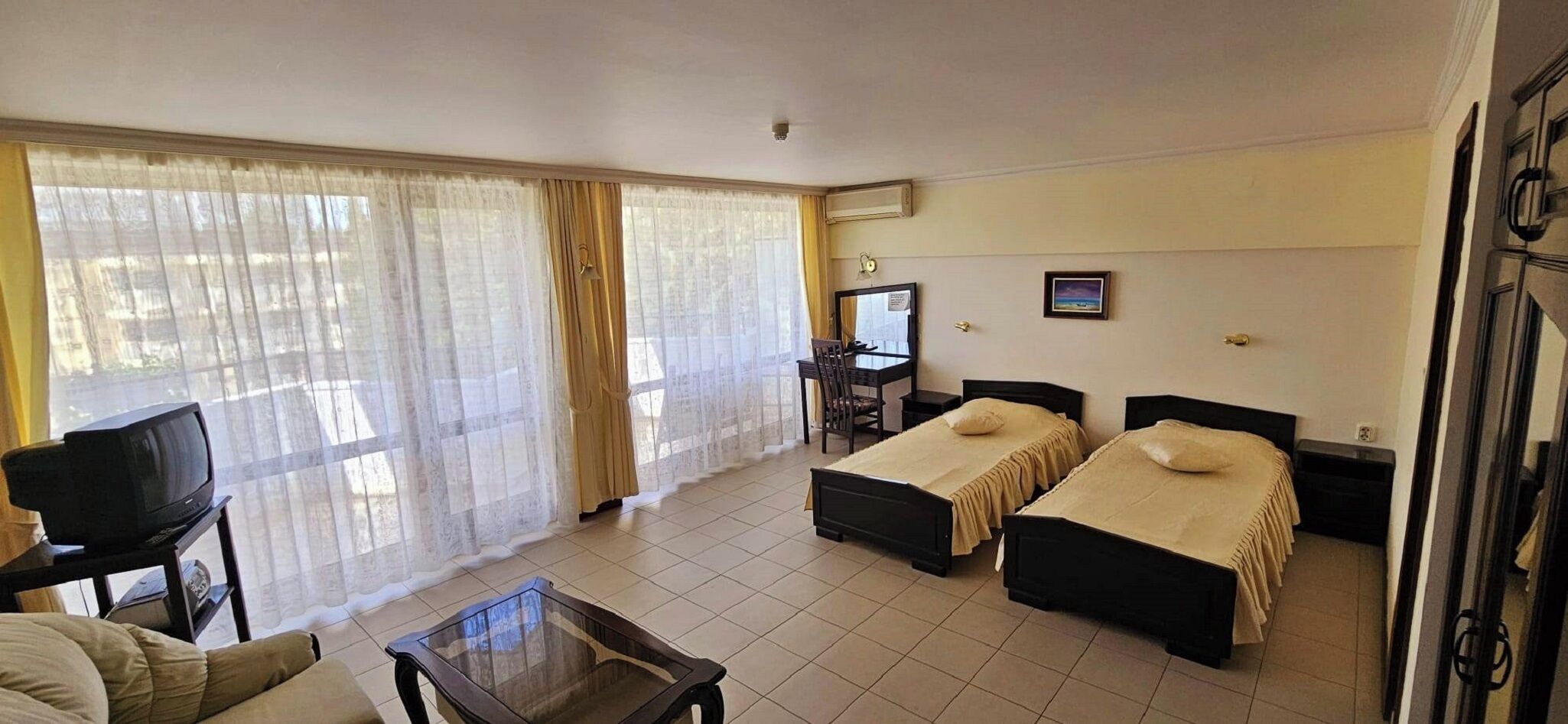 Une chambre d’hôtel avec deux lits, une télévision, un bureau et une chaise.