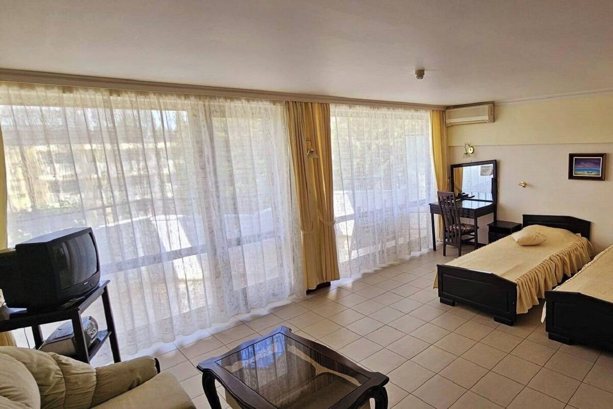 Une chambre d’hôtel avec deux lits, une télévision, un bureau et une chaise.
