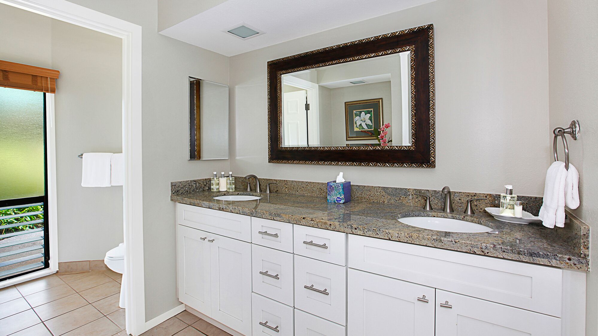 A modern bathroom with two sinks, a large mirror, and a vanity with drawers.