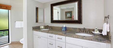 A modern bathroom with two sinks, a large mirror, and a vanity with drawers.