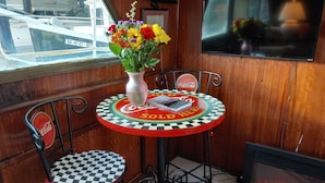 A cozy corner with a table and chairs, a vase with flowers, and a fireplace.