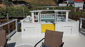 A boat deck with seating, a pool, and a view of the surrounding landscape.