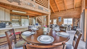 A wooden interior with a dining area, kitchen, and a staircase leading to an upper level. - Spacious Hilltop Cabin w/ Deck & Scenic Views! (Eden)