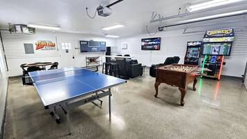 Relax and have fun in this recreational room, featuring a ping pong table, foosball table, and TV for entertainment.