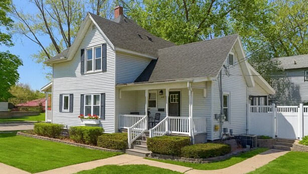 A two-story house with a front porch, a chimney, and a well-maintained lawn. - Field House | Game Room | DOWNTOWN Dells | Basketball Court| Arcade (Wisconsin Dells)