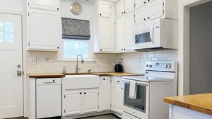 A kitchen with white cabinetry, a microwave, an oven, and a dishwasher. - Field House | Game Room | DOWNTOWN Dells | Basketball Court| Arcade (Wisconsin Dells)