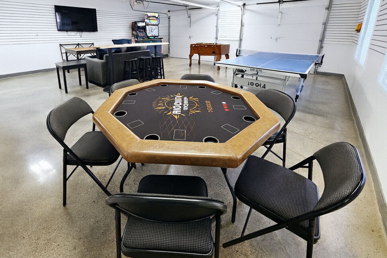 Ein sechseckiger Tisch mit schwarzer Oberfläche und goldener Zierleiste, umgeben von sechs schwarzen Stühlen.