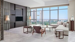 Una sala de estar moderna con un ventanal grande, un sofá, una mesita de centro y un televisor.