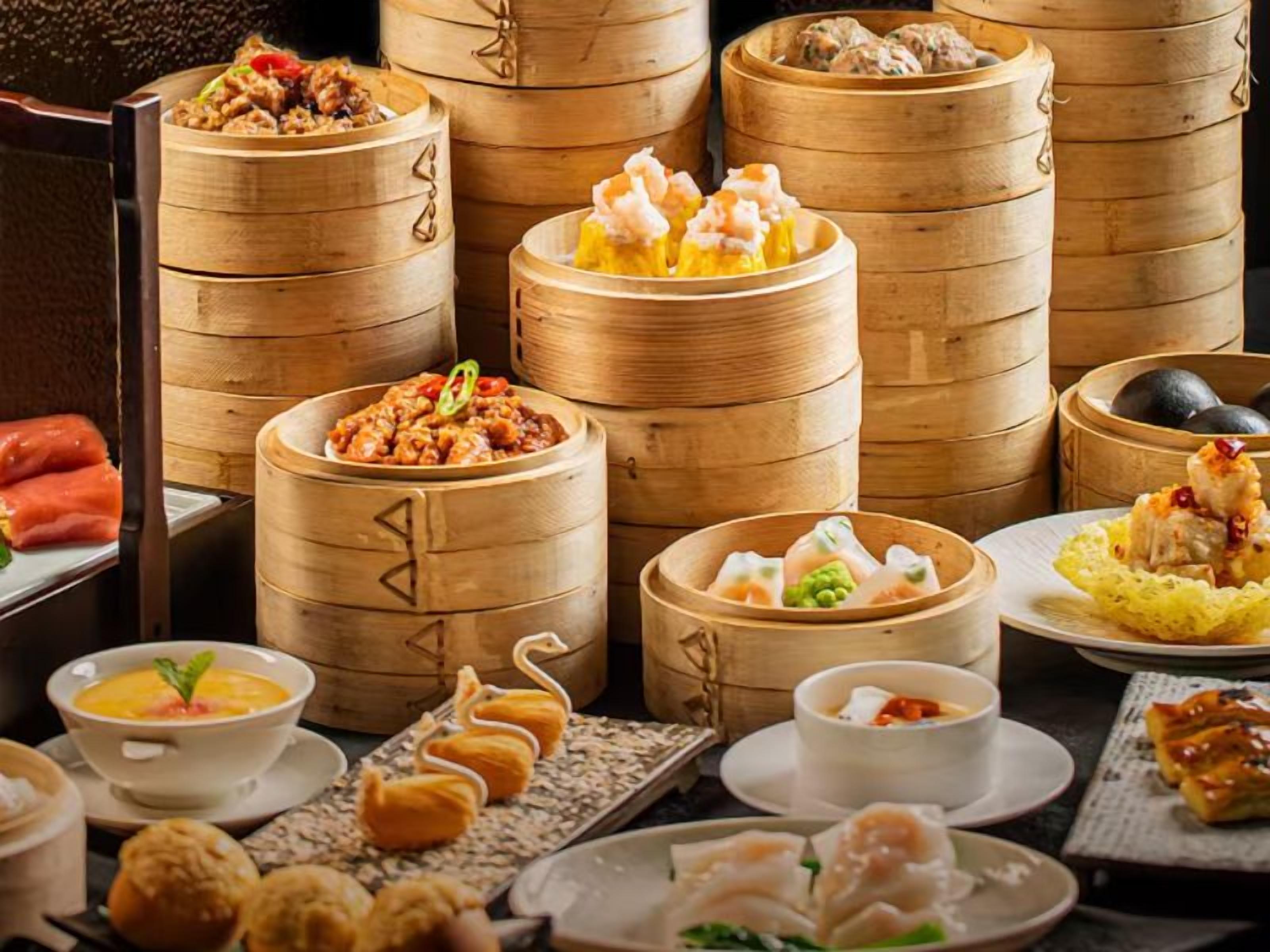 A variety of food items, including dumplings and a bowl of soup, arranged on a table.