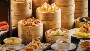 A variety of food items, including dumplings and a bowl of soup, arranged on a table.
