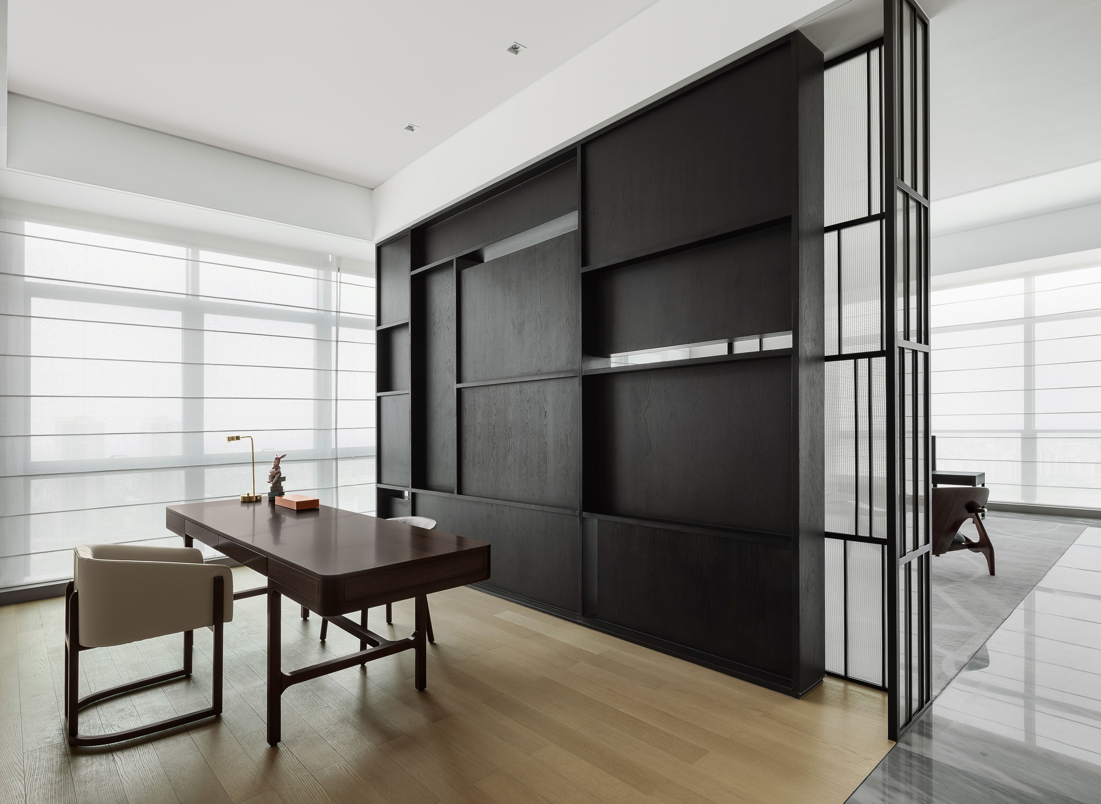 A modern interior with a dark wooden wall unit, a wooden table, and a chair.