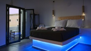 Un dormitorio moderno con cama, lámparas de noche y una puerta de cristal que da a un espacio exterior.