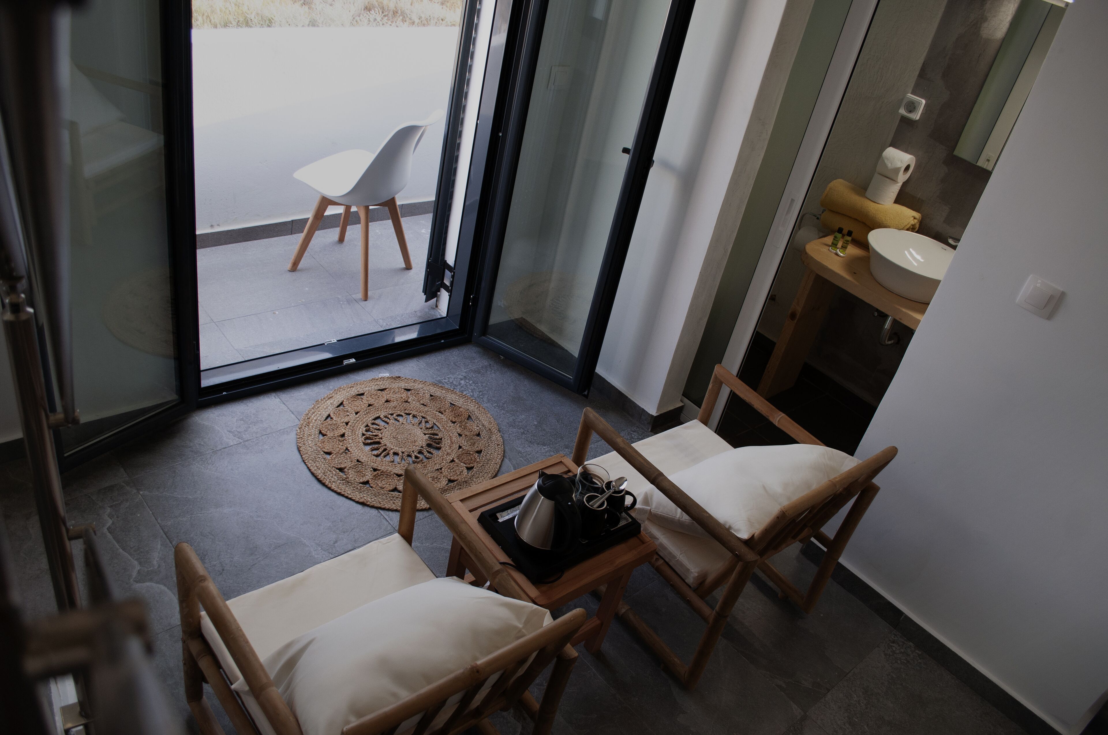 A modern interior with a seating area featuring two wooden chairs and a small table with a tray.