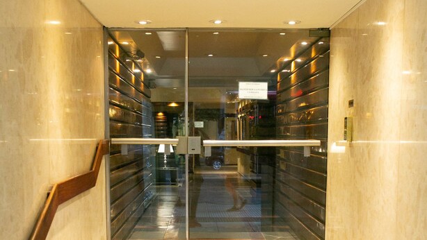 A set of marble stairs leading to a glass elevator entrance. - Santa Fe by BA Tango Apartments (Buenos Aires)
