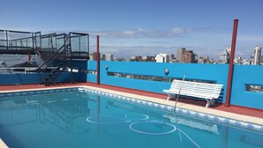 A rooftop pool with a blue wall, a white bench, and a glass enclosure. - Santa Fe by BA Tango Apartments (Buenos Aires)