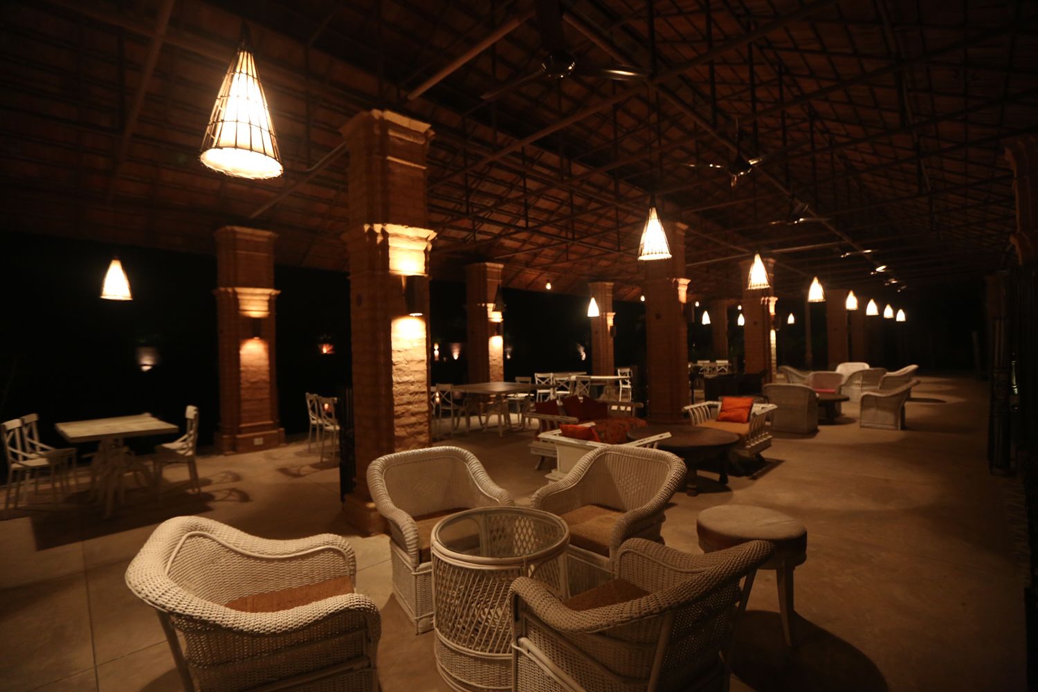 An indoor seating area with wicker furniture and hanging lights.