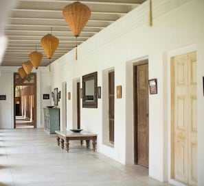 A hallway with doors, a bench, and hanging lanterns. - The Rajbari Bawali (Alipur)