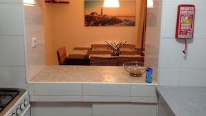 A kitchen with a dining area, a painting on the wall, and a fire extinguisher. - Beautiful Townhouse for golfers and beach holidays in sunny Vilamoura (Vilamoura)