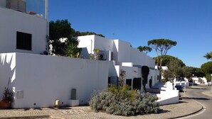 A street with white buildings, cobblestone pavement, and a clear blue sky. - Beautiful Townhouse for golfers and beach holidays in sunny Vilamoura (Vilamoura)