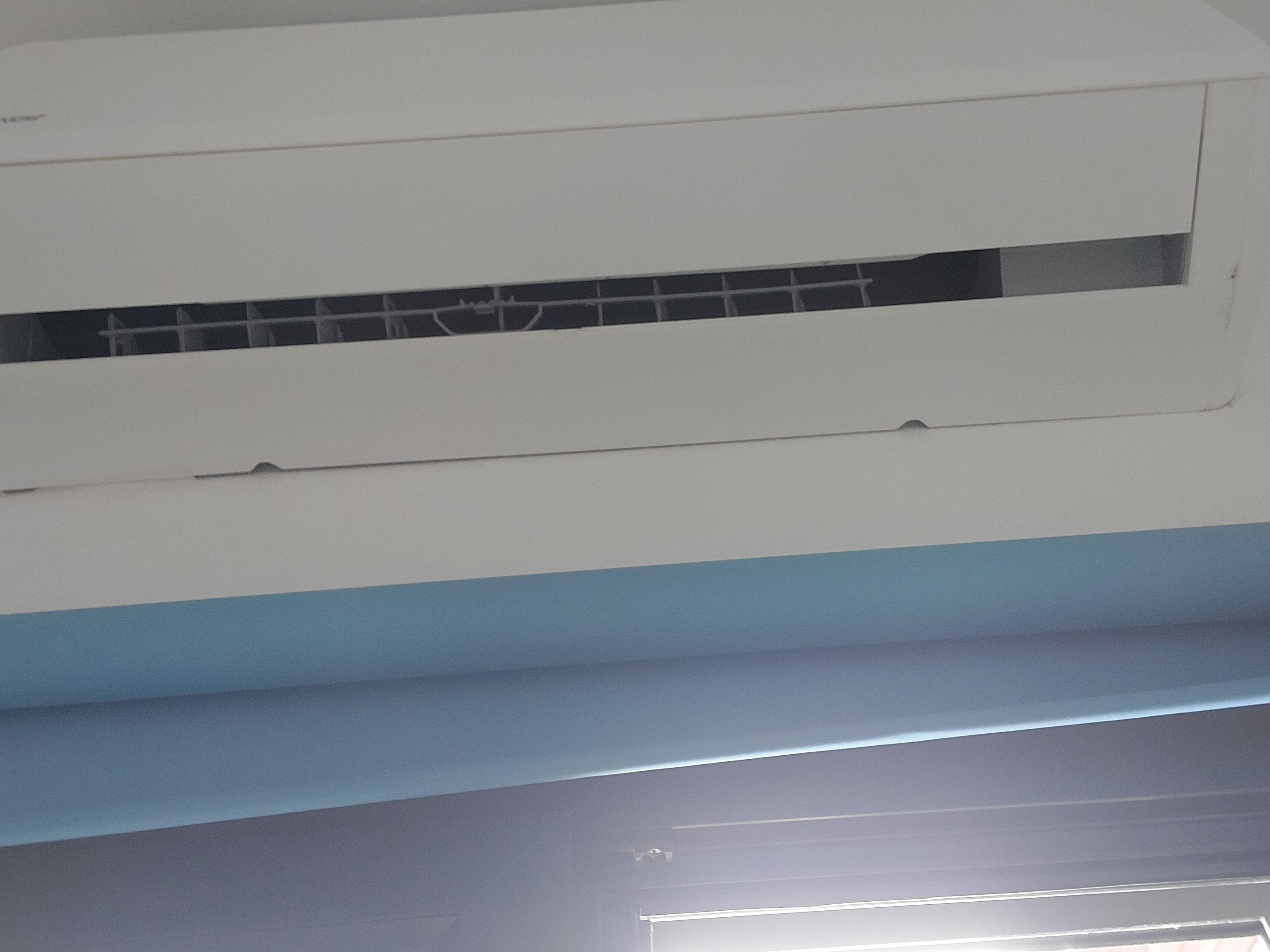 A white and blue air conditioning unit with a visible control panel and a small vent.