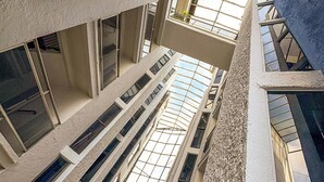 Un edificio moderno con varios pisos, amplios ventanales y un atrio central que permite el ingreso de luz natural.