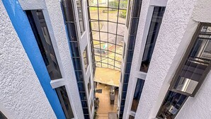 Un edificio de varios niveles con una escalera central, ventanas grandes y vistas del entorno.