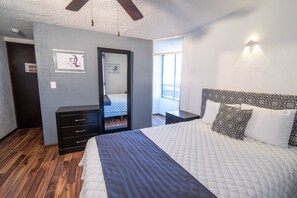 A bedroom with a bed, a dresser, a mirror, and a window. - Hotel Delf-inn (Jiutepec)