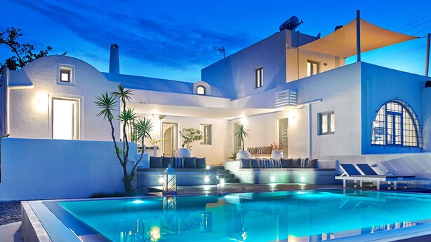 Una villa moderna con piscina, mobiliario exterior y una zona de patio cubierta.