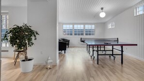 A spacious room with a ping pong table, a potted plant, and a bench. - 5 bedroom beautiful home in Otterup (Otterup)
