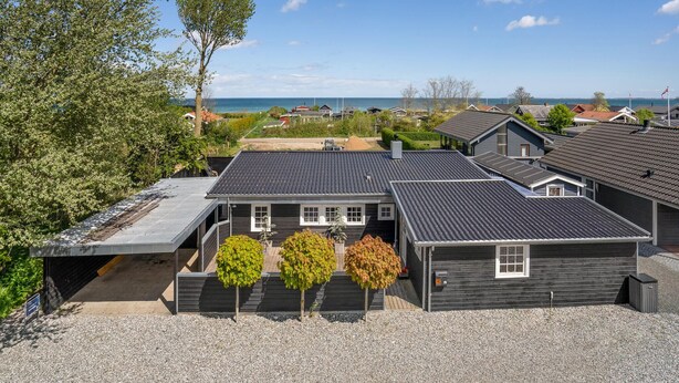 A residential area with houses, a gravel driveway, and a view of the sea. - 5 bedroom beautiful home in Otterup (Otterup)