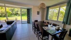 A dining area with a table and chairs, a bench, and a view of the outdoors.