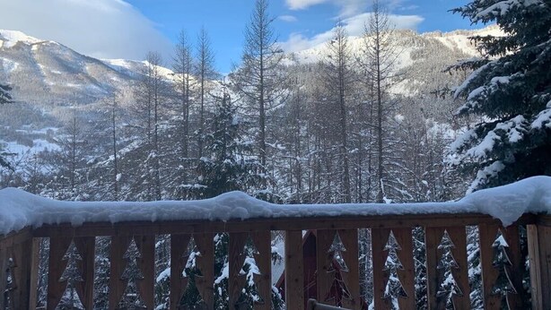 A wooden deck with snow-covered railings overlooking a mountainous landscape with snow-covered trees and a clear blue sky. - Beau Chalet 9 persons, 5 rooms, 120m2 in Allos (Allos)