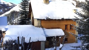 A wooden cabin with a snow-covered roof, surrounded by trees and mountains. - Beau Chalet 9 persons, 5 rooms, 120m2 in Allos (Allos)