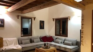 A living room with a grey sofa, a wooden coffee table, and a wooden ceiling. - Beau Chalet 9 persons, 5 rooms, 120m2 in Allos (Allos)