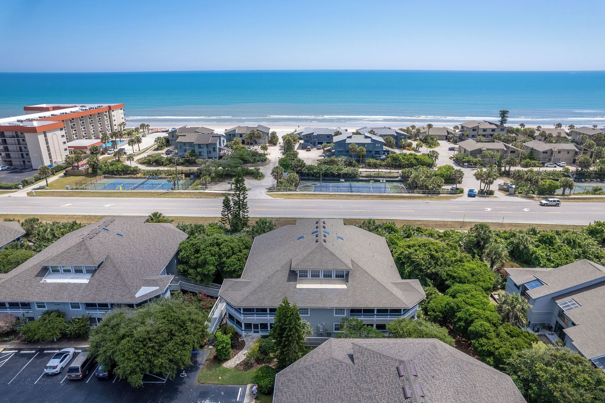 A coastal residential area with a beachfront view, including a hotel and several houses.