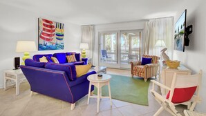 A modern living room with a blue sofa, striped armchairs, and a small white table.