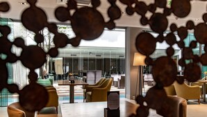A modern interior with a wooden table, yellow chairs, and a glass wall. - Caseros 248 Hotel (Córdoba)