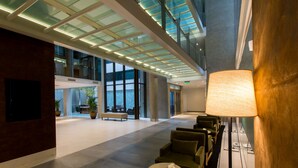 A spacious lobby with a high ceiling, large windows, and modern seating areas. - Caseros 248 Hotel (Córdoba)