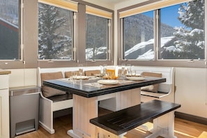 Enjoy meals with a view of the serene mountain landscape from this dining area with a large table for four.