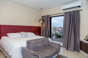 Minibar, escritorio, cortinas blackout y tabla de planchar con plancha