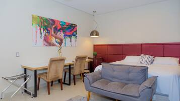 Minibar, escritorio, cortinas blackout y tabla de planchar con plancha
