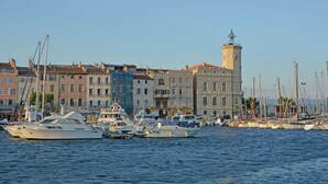 A marina with boats docked, buildings with balconies, and a tower with a clock. - Mas in Eygalières with Heated Pool (Eygalières)
