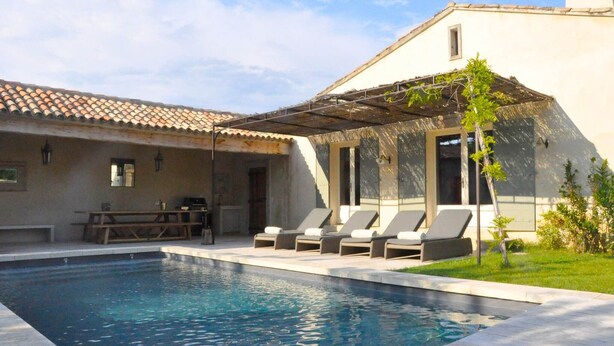 A pool area with lounge chairs, a table, and a pergola. - Mas in Eygalières with Heated Pool (Eygalières)