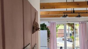 A room with a wooden ceiling, a bed with a patterned bedspread, and a view of the outside. - Oak Cottage: A Breathtaking Barn Retreat with a Private Log-Fired Hot Tub (maidstone)