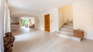 A spacious hallway leading to a staircase with a wicker basket on the landing. - Villa Saint-Tropez (Gassin)