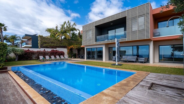 A modern two-story house with a swimming pool, outdoor furniture, and a view of the sea. - Villa Vitória by LovelyStay (Funchal)