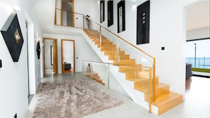 A modern interior with a staircase, a rug, and artwork on the walls. - Villa Vitória by LovelyStay (Funchal)