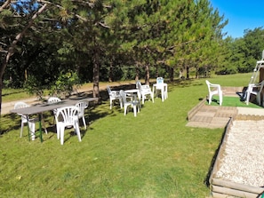 A grassy outdoor area with white plastic chairs and tables arranged for outdoor dining. - Homerez - Chalet in Les Tourettes (Les Tourettes)
