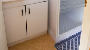 Un baño con lavamanos, espejo y armarios blancos.